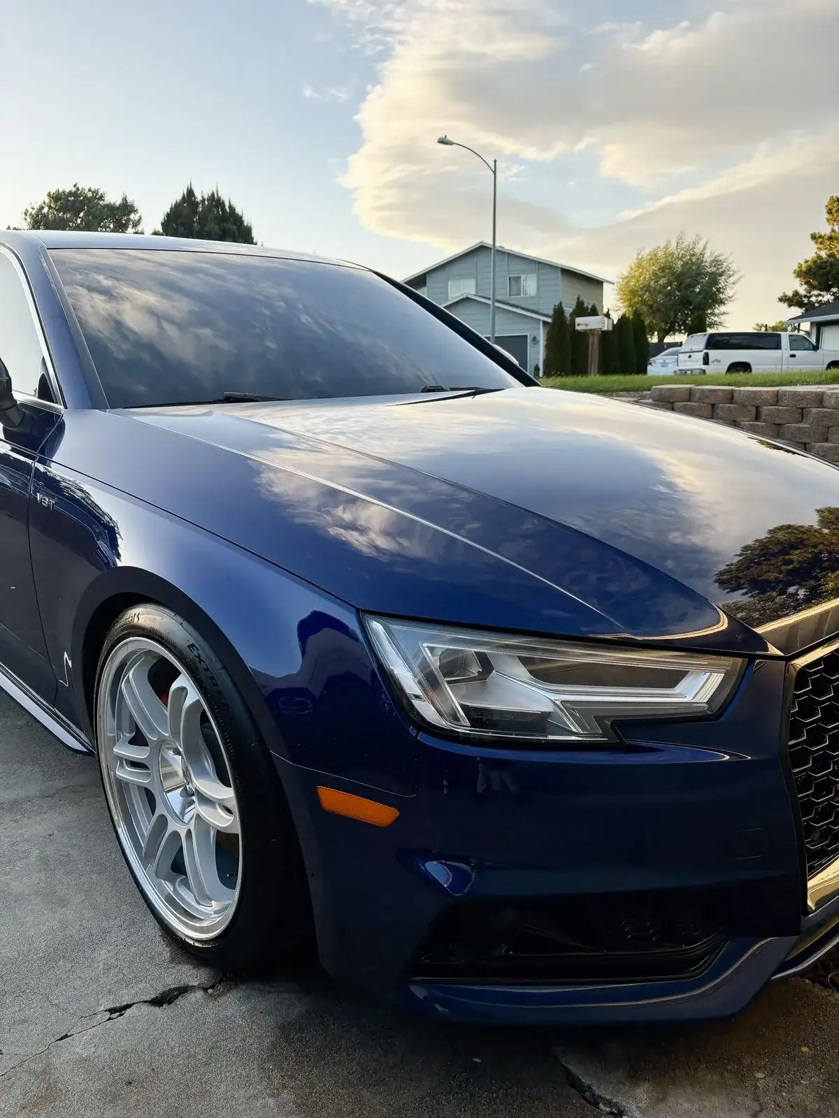 Dark blue sedan with deep, glossy paint after a clay and seal treatment