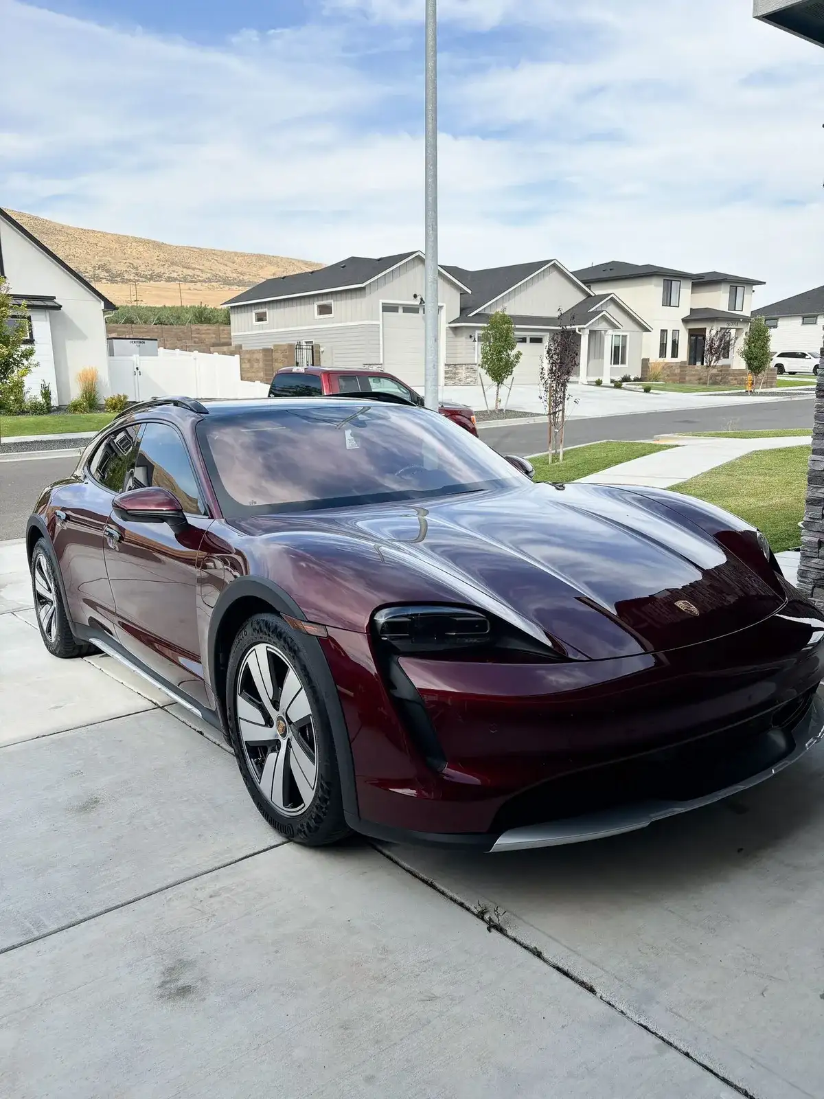 Burgundy Porsche Taycan shining in the sun after a Premium Exterior Detail