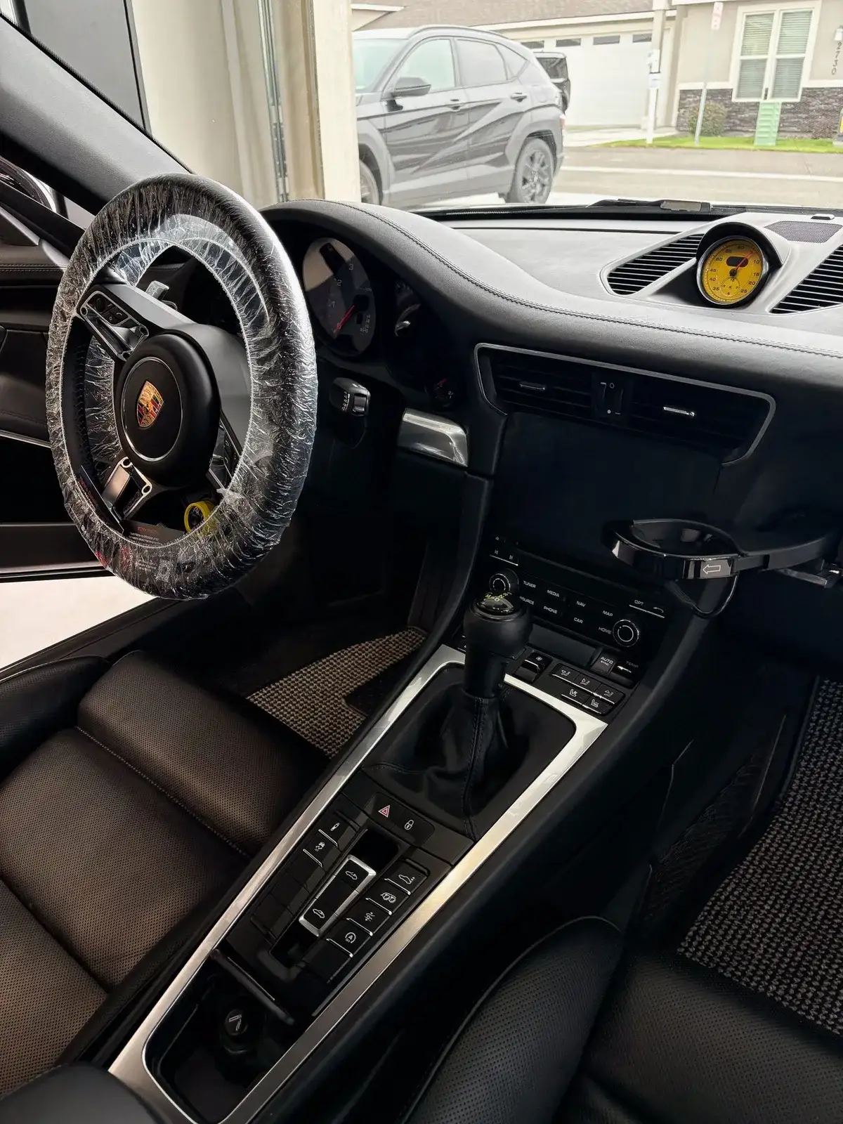 Porsche 911 cabin after a Masterpiece Detail, with the steering wheel wrapped to keep it clean