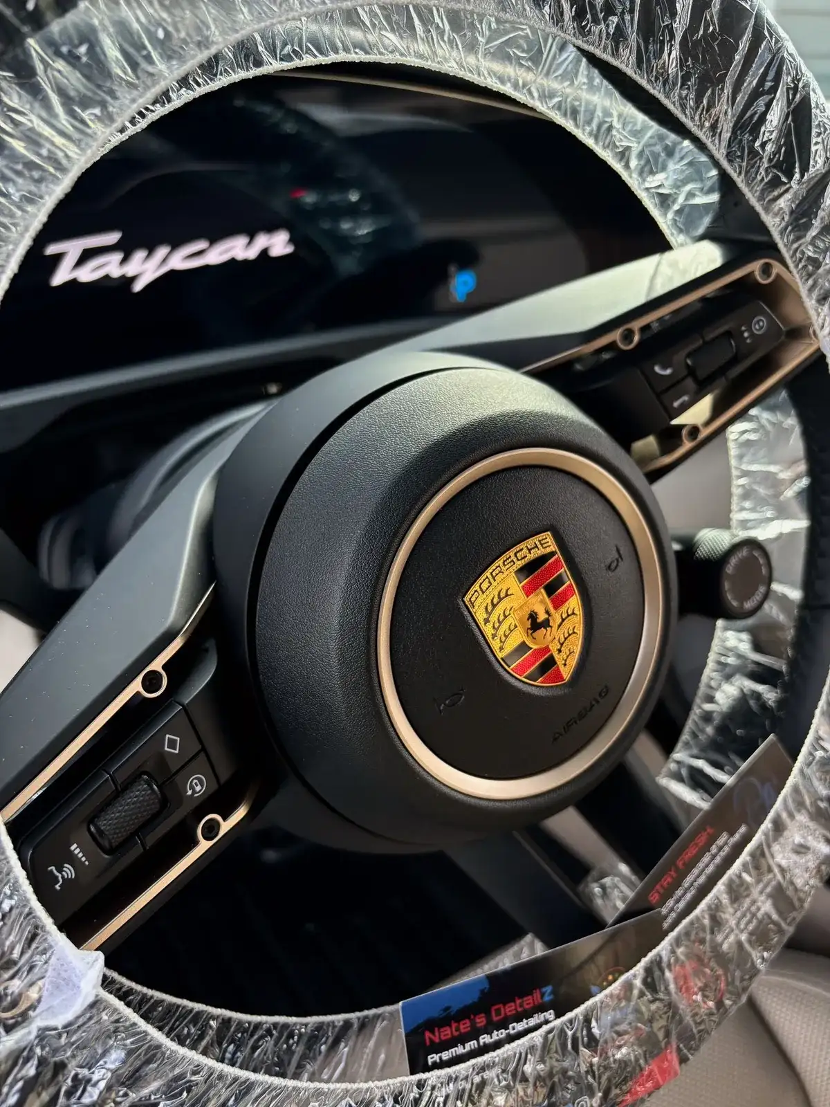 Porsche Taycan steering wheel, wrapped and spotless after a Premium Interior Detail