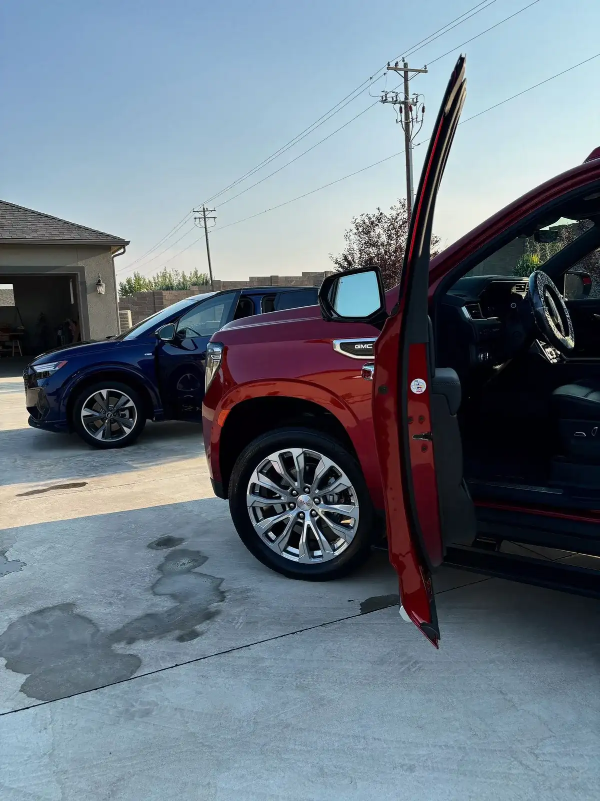 A red pickup with its door open beside a blue SUV, both detailed for one couple