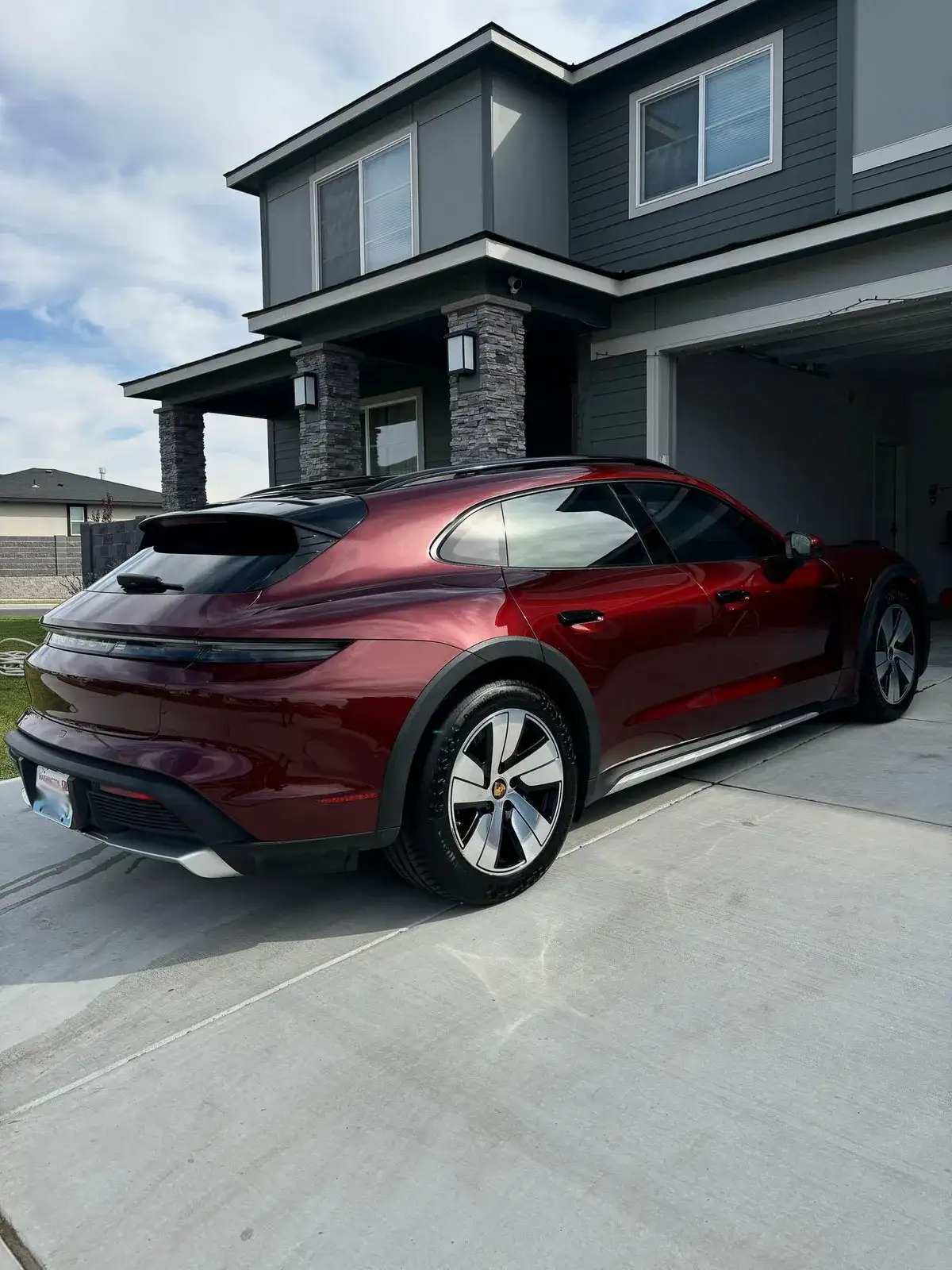 Burgundy Porsche Taycan wagon in a driveway after a Masterpiece Detail