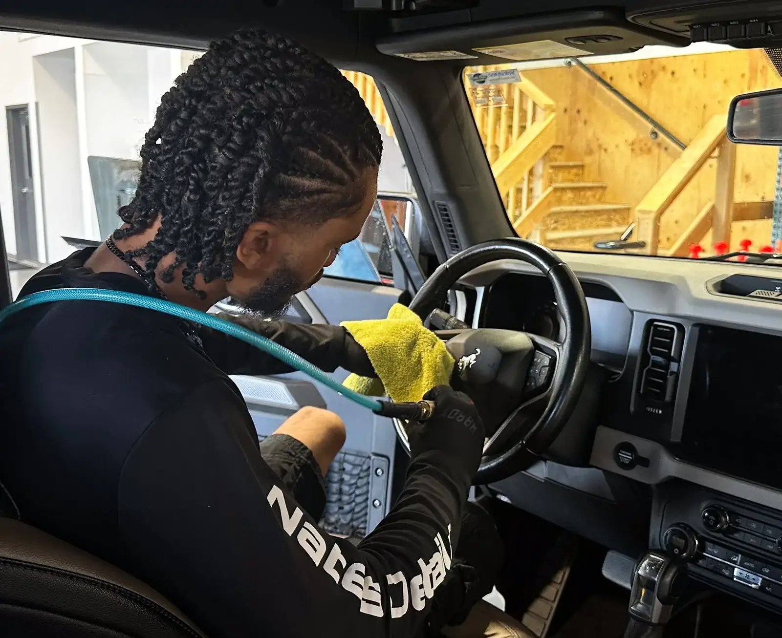 Nate cleaning a steering wheel during a Premium Interior Detail